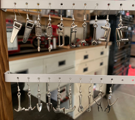a variety of tool shapes earrings on an earring stand