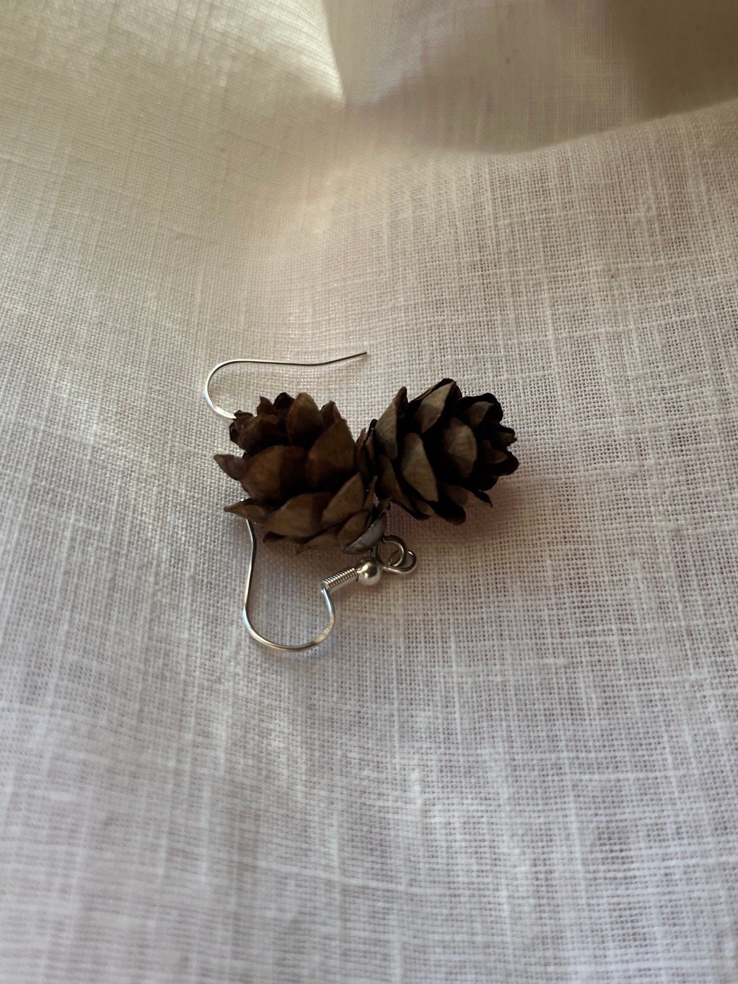 mini pine cone earrings on linen