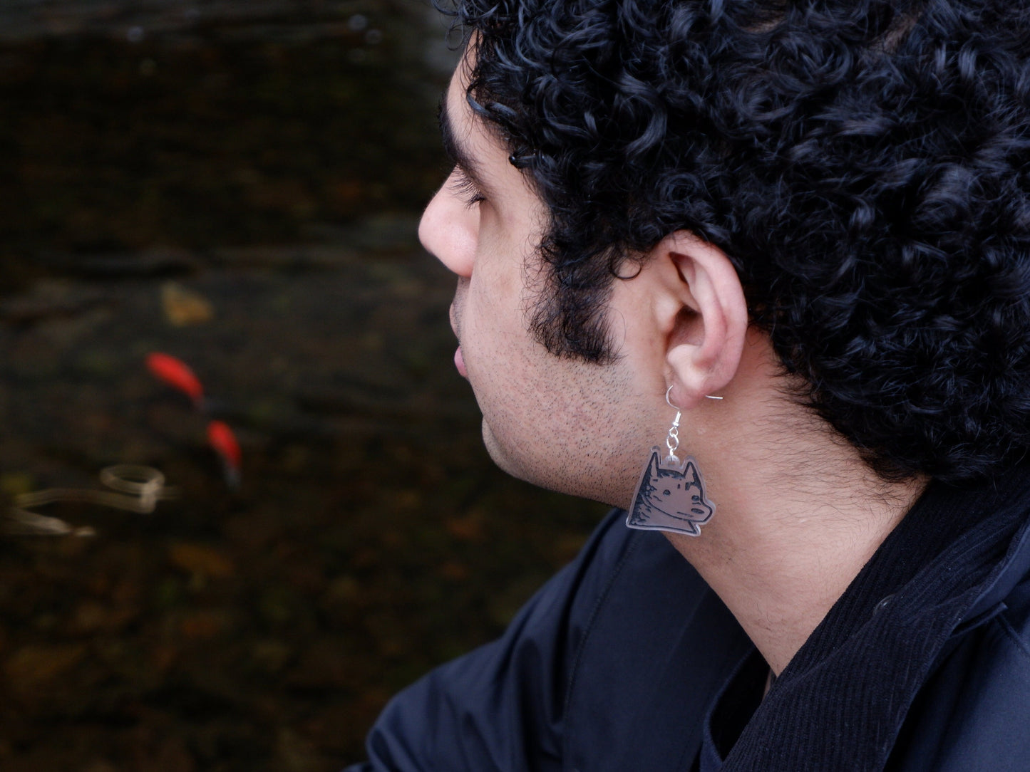 dog earrings being worn by a man by a pond