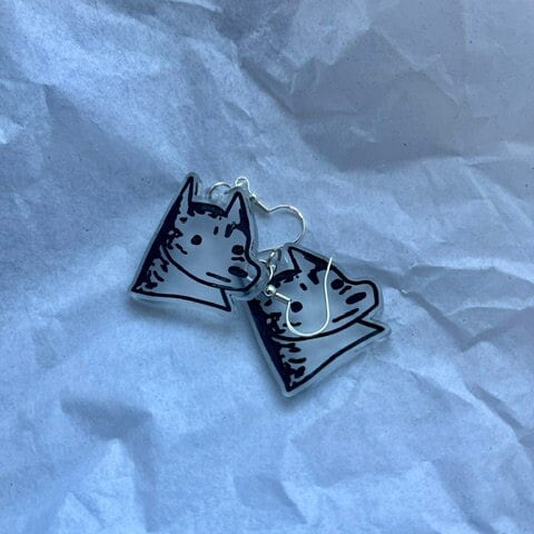 transparent dog earrings on a sheet of paper